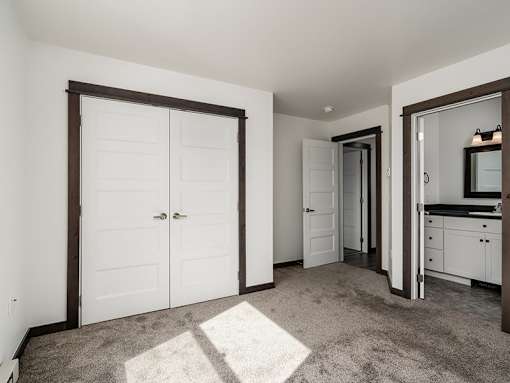 A room with a white door and a carpet on the floor.