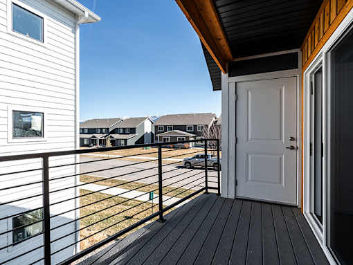 A balcony with a white door and a black railing.