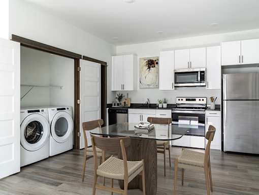A modern kitchen with a dining table and chairs.