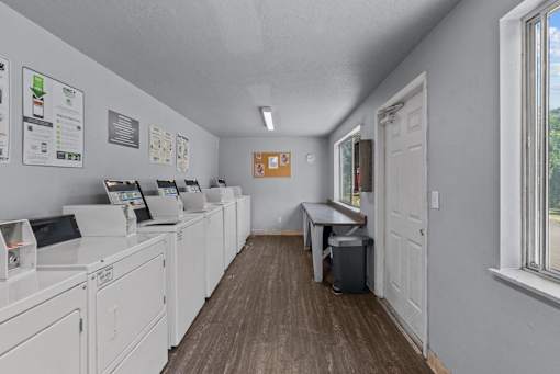 A laundromat with washers and dryers lined up on the left.