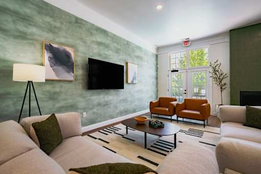 A living room with a white couch and a green wall.