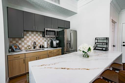 A kitchen with a white counter top and wooden cabinets.