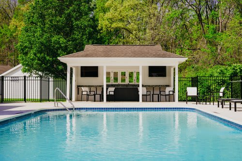 A pool with a pavilion in the background.