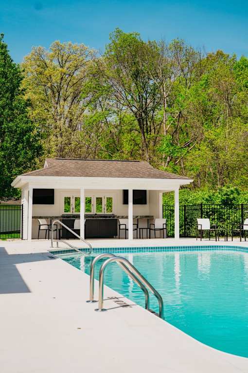 A pool with a pavilion in the background.