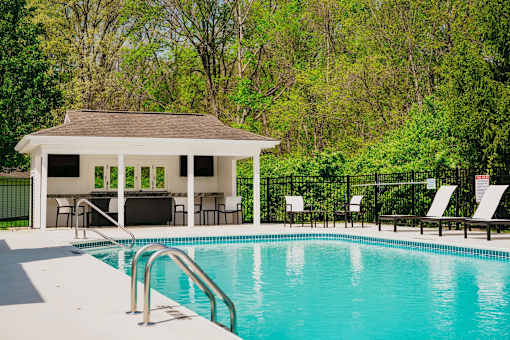 A pool with a pavilion in the background.