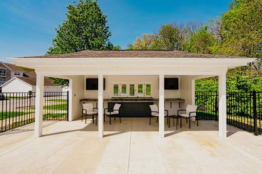 A white covered patio with a table and chairs.