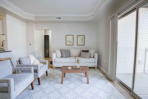 A living room with a grey couch, a white couch, and a wooden coffee table.