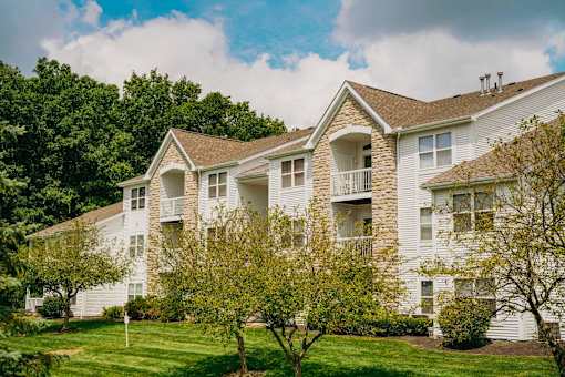 A white apartment building with a green lawn in front.