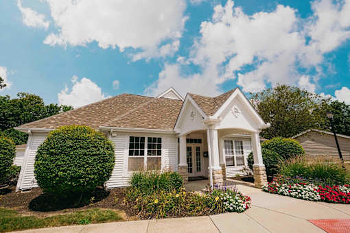 A white house with a brown roof and a small front porch.