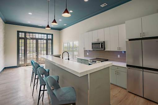 A kitchen with a white counter and blue chairs.