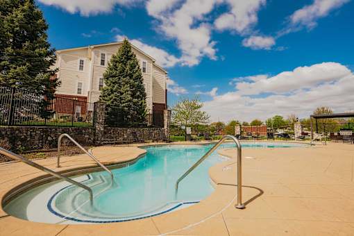 A swimming pool with a slide in front of a residential building.