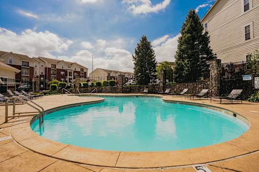 A swimming pool in a residential area with a clear blue sky.