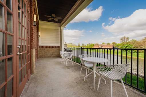 A patio with a table and chairs overlooking a body of water.