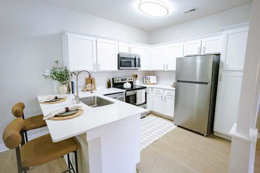 A kitchen with white cabinets and a white island.