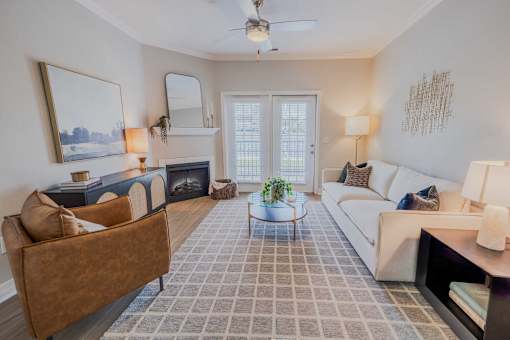 A living room with a brown couch, a white couch, a coffee table, and a painting on the wall.