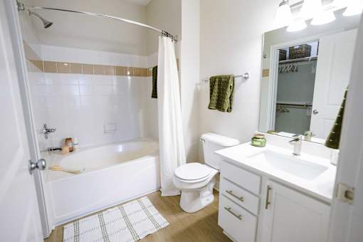 A white bathroom with a toilet, sink, and bathtub.