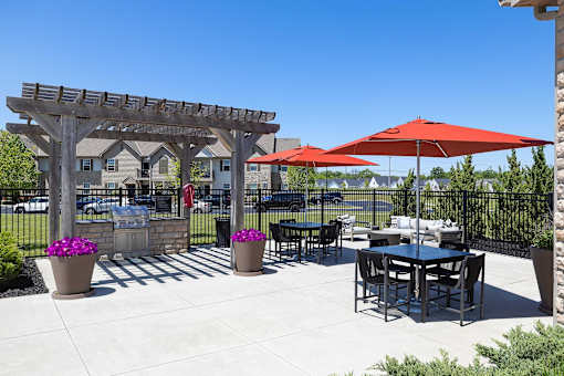 A patio with a table, chairs and umbrellas.