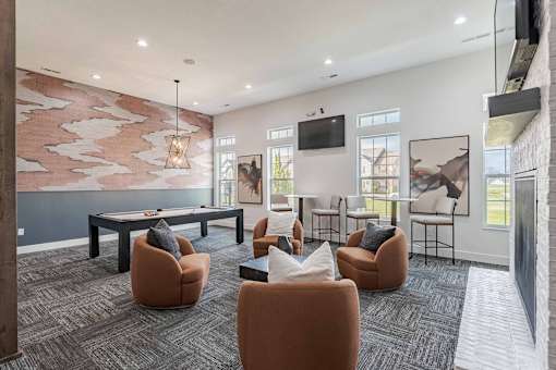 A modern living room with a grey carpet and a large painting on the wall.