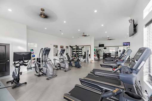 A gym with treadmills, elliptical machines, and other exercise equipment.