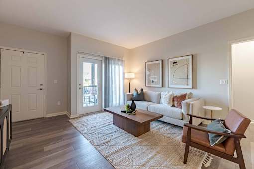 A living room with a couch, a coffee table, and a chair.