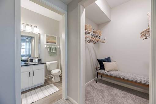 A bathroom with a toilet, sink, and a window.