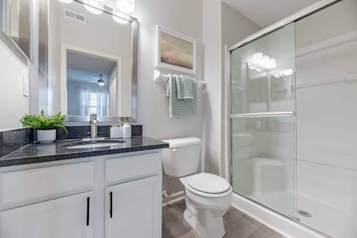 A bathroom with a white toilet and a glass shower stall.