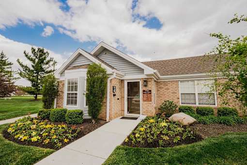 A house with a front yard and a walkway leading to the front door.
