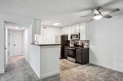 A kitchen with a white counter and a black refrigerator.