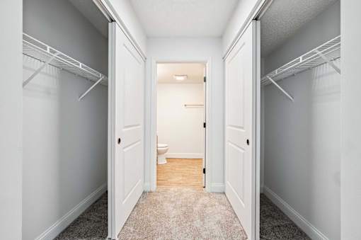 A hallway with white walls and a carpeted floor.