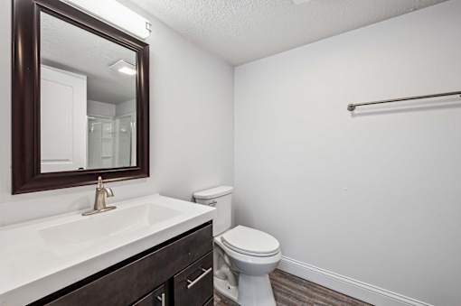 A white toilet sits next to a sink in a bathroom.