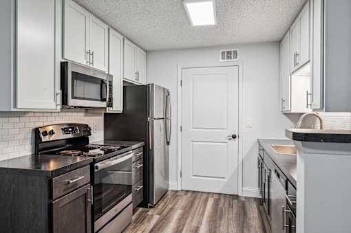 A kitchen with a black stove top oven and a black refrigerator.