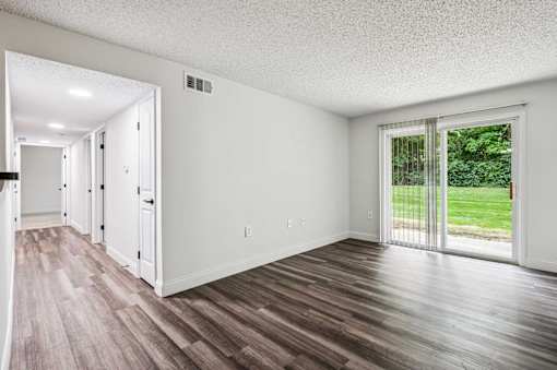 A room with a sliding glass door leading to a backyard.