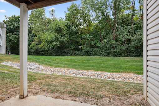 A grassy area with a gravel path and a wooden post.