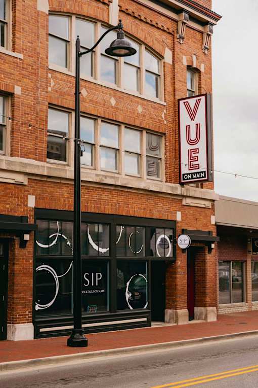 A red brick building with a black sign that says VUE on it.