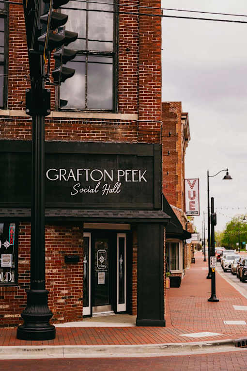 The Grafton Peek Social Hall is a brick building with a black awning.