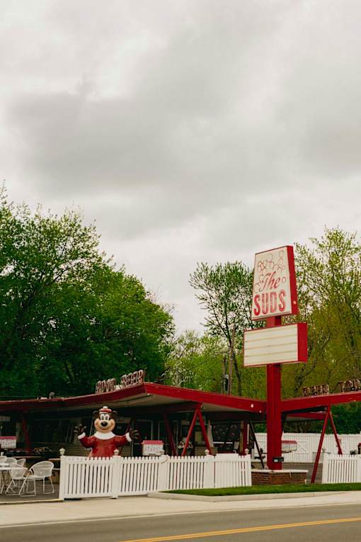 A restaurant with a red and white sign that says "The Suds".