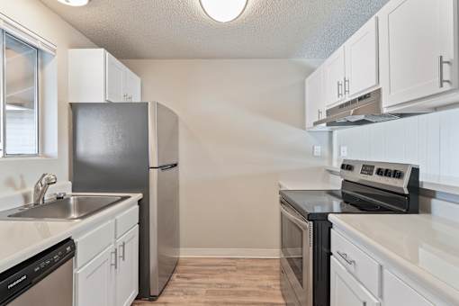 A kitchen with white cabinets and black appliances.