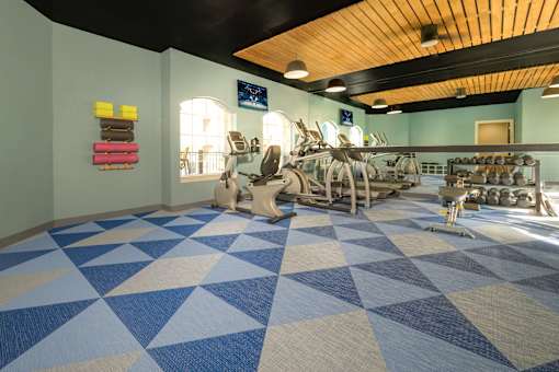 A room with a blue and white tiled floor and exercise equipment.