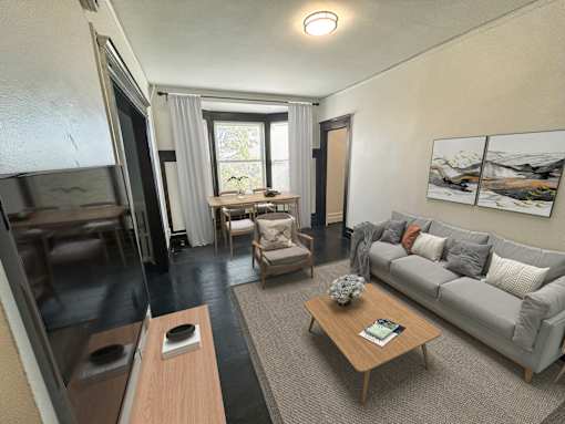 A living room with a grey couch, a wooden coffee table, and a flat screen TV.