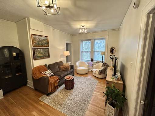 A living room with a brown couch and a fireplace.