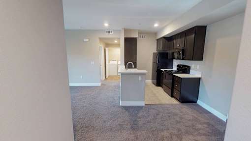 a kitchen and living room with a black stove and at Edgewater, Pittsburg, CA  