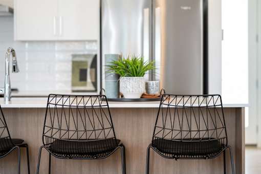 Two black chairs are placed in front of a kitchen counter.