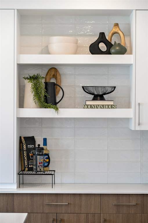A kitchen cabinet with a white interior and shelves containing various items.