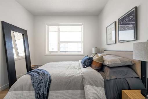 A bedroom with a large bed and a window.
