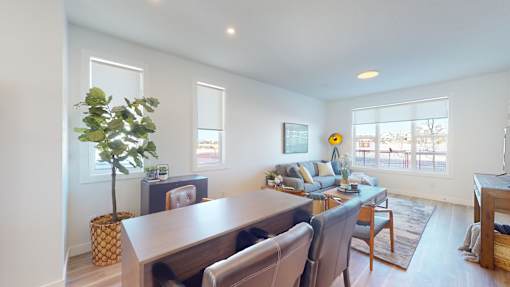 A living room with a dining table and chairs.