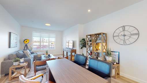A living room with a long wooden table and chairs.