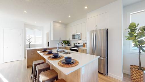 A modern kitchen with a white countertop and stainless steel appliances.