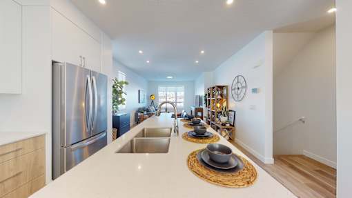 A modern kitchen with a stainless steel refrigerator and a wooden countertop.