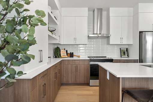 A modern kitchen with wooden cabinets and a stainless steel refrigerator.