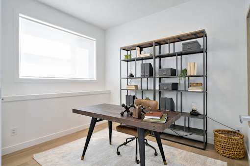 A room with a desk and a shelf with various items on it.